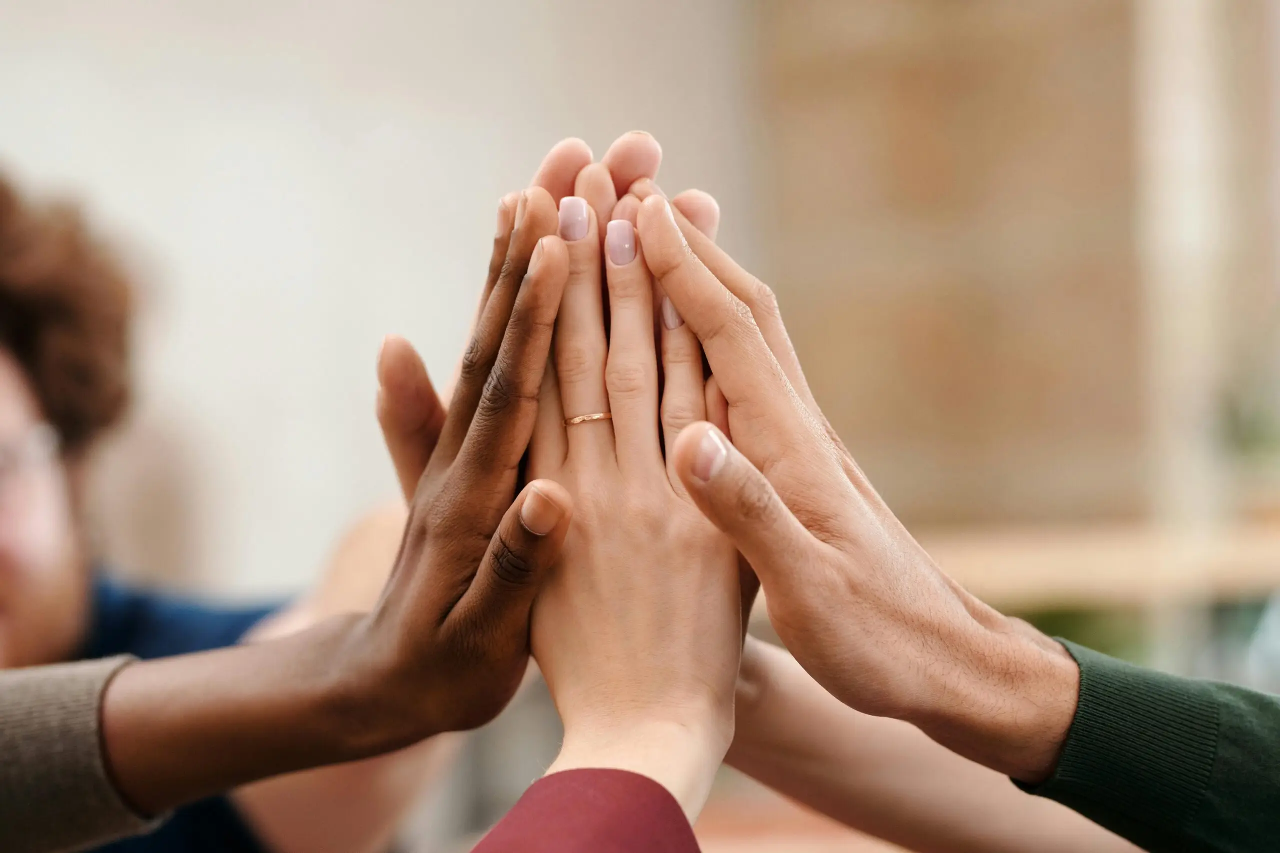 Close-up of diverse group hands high-fiving symbolizing teamwork and unity.