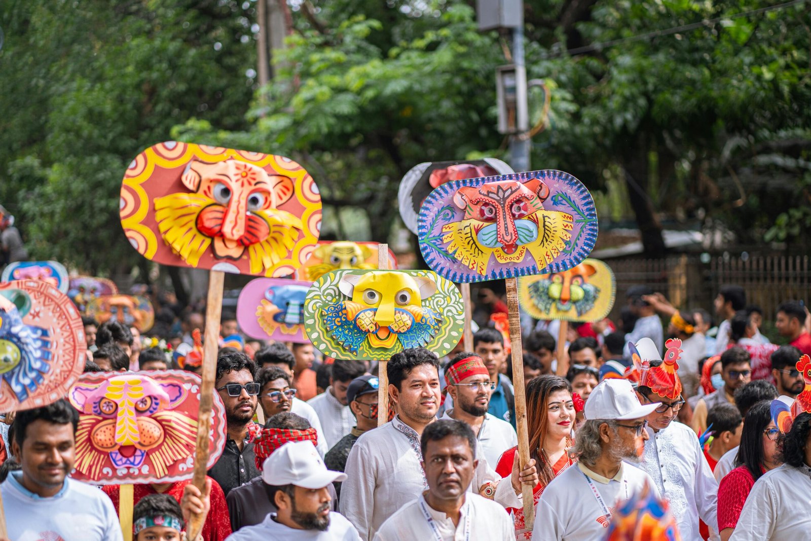 Colorful parade featuring traditional mask designs and large crowd at outdoor festival.